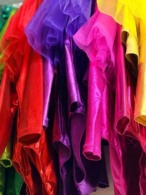 Glänzende Showtanzkostüme in Rot, Lila, Pink und Gold mit Tüllrüschen